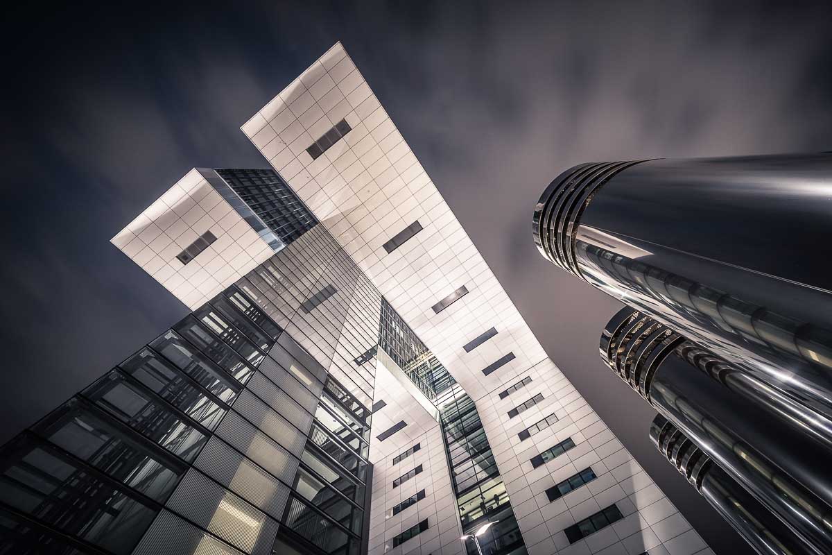Steile Untersicht eines Kölner Kranhauses mit Architekturlinien und verchromten Abluftschächten